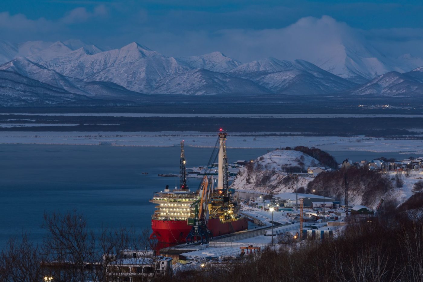 Інженер оглядає газопровід на тлі засніжених гір Аляски.